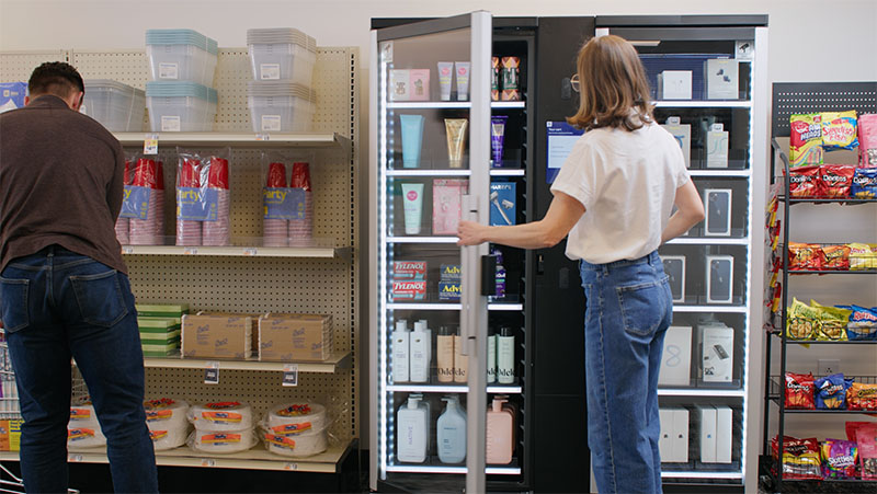 A woman shops at a Smart Store placed between two shelves in a retail store.